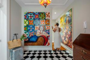 a woman standing in front of a painting on a wall at Villa Til Gallery in Funchal