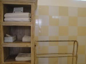 a bathroom with a book shelf with towels at Scallywags Mango in Gili Air