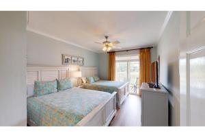 a bedroom with two beds and a flat screen tv at Litchfield Beach Retreat Lakeside Villa Serenity in Pawleys Island