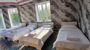 a room with four beds and two windows at Elizabet guest house in Kerben