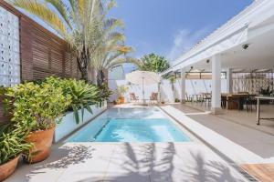 a swimming pool in a house with plants at Casa no condomínio Reserva Ecológica do Sahy in Mangaratiba