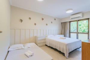 a bedroom with two beds and a window at Casa no condomínio Reserva Ecológica do Sahy in Mangaratiba