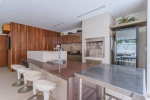 a kitchen with a large counter with stools in it at Casa no condomínio Reserva Ecológica do Sahy in Mangaratiba