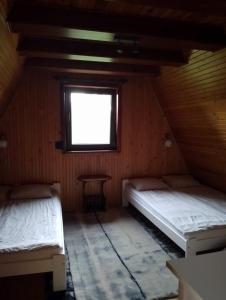 Postel nebo postele na pokoji v ubytování Dom na Kaszubach Sulęczyno z widokiem na jezioro
