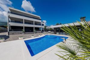 a house with a swimming pool in front of a building at VILLA Juky in Kaštela