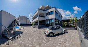 a small white car parked in front of a building at VILLA Juky in Kaštela