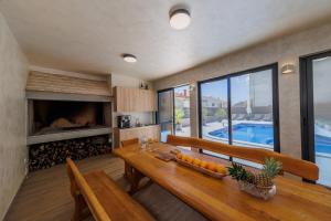 a dining room with a wooden table and a fireplace at VILLA Juky in Kaštela