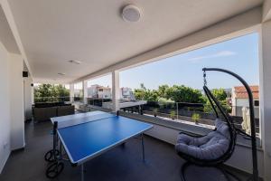 a room with a ping pong table and a swing at VILLA Juky in Kaštela