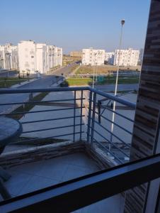 a balcony with a view of a street and buildings at appartement 75m2 avec piscine in Bouznika