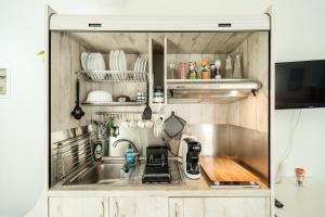 eine kleine Küche mit einer Spüle und einer Theke in der Unterkunft Seaside Studio in Nea Peramos, Sleeps 4 in Néa Péramos