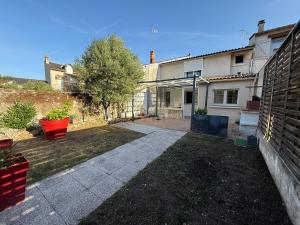 a backyard of a house with a driveway at Maison de Coeur - Futuroscope in Jaunay-Clan