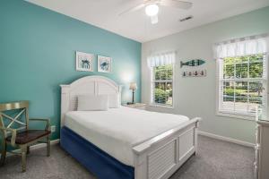 a bedroom with a white bed and two windows at Magnolia Run 13 3BR 2BA in Pawleys Island