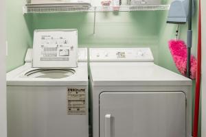 a small kitchen with a stove and a washer and dryer at Magnolia Run 13 3BR 2BA in Pawleys Island