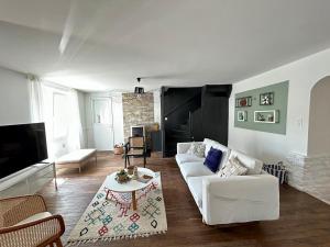 a living room with a white couch and a table at Maison de Coeur - Futuroscope in Jaunay-Clan