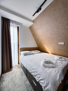una camera da letto con un grande letto con lenzuola bianche di 3N Royal Mountain a Divčibare