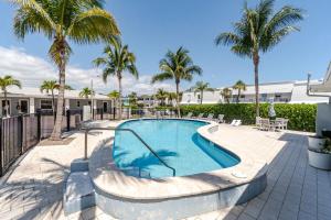 a swimming pool with palm trees and a resort at Bliss stylish apartment with pool, by beach in Riviera Beach
