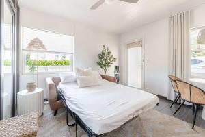 a white bedroom with a bed and a table at Bliss stylish apartment with pool, by beach in Riviera Beach +19 photos