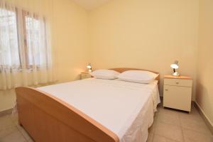 a bedroom with a bed with two pillows on it at Apartments Milena in Stomorska