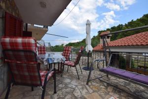 a balcony with a table and chairs and an umbrella at Apartments Milena in Stomorska