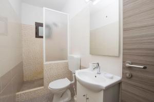 a white bathroom with a toilet and a sink at Apartments Adriana in Klenovica +48 photos