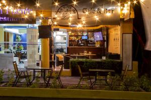 a restaurant with tables and chairs at night at Hotel Elizabeth Ciudad Deportiva in Aguascalientes