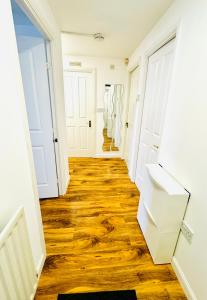 a hallway with white doors and wooden floors at Modern 2 Bedroom GF - Aberdeen City Centre - Private Car Park in Aberdeen