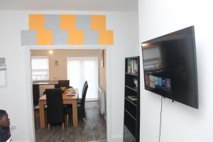 a living room with a television and a dining room at Tastefully furnished and Cosy 2-bedroom house in South Shields +16 photos