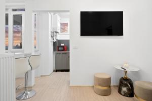 a living room with a tv on a white wall at Victoriei Avenue Gem in Bucharest