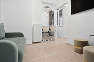 a living room with a couch and a table and chairs at Victoriei Avenue Gem in Bucharest