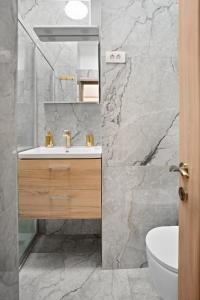 a bathroom with a sink and a marble wall at Victoriei Avenue Gem in Bucharest +17 photos