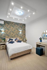 a bedroom with a bed and a wall with a blue ceiling at Victoriei Avenue Gem in Bucharest