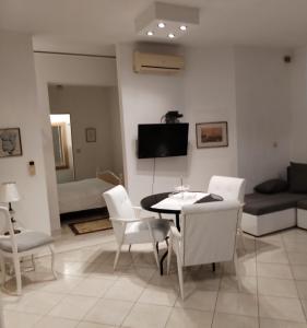 a living room with a table and white chairs at Villa Angel sea view in Trogir