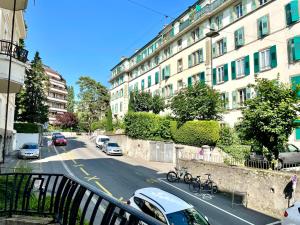 eine Stadtstraße mit Autos, die an der Seite eines Gebäudes geparkt sind in der Unterkunft Appartement à 9 minutes à pied de la gare de Lausanne in Lausanne