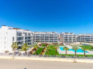 Un gran edificio de apartamentos con piscina y palmeras. en Ema Residencial, en Villamartin