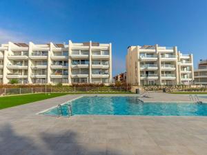 Un gran edificio de apartamentos con piscina frente a un edificio. en Ema Residencial, en Villamartin