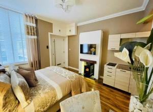 a bedroom with a bed and a fireplace and a tv at Isle Be Back-Ground Floor Flat in Millport