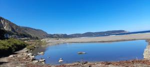 a large pool of water with mountains in the background at Ema Juan in Navidad