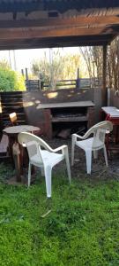 two white chairs and a table and a piano at Ema Juan in Navidad