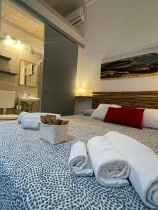 - une chambre avec 2 lits et des serviettes dans l'établissement Camere a Oriente, à Torre dell'Orso