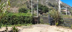 a fence in the middle of a field with a mountain at Ema Juan in Navidad