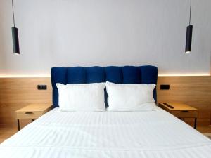 a bed with a blue headboard and two white pillows at VeRa Suite 2 in Silistra