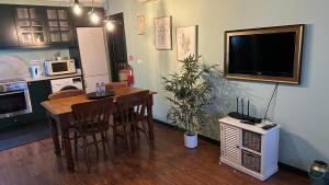 Una cocina con mesa de comedor y televisión. en Studio by Casa da Quinta, en Funchal
