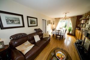 a living room with a brown leather couch and a table at Danabel B&B in Kinsale