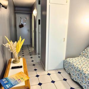a small room with a bed and a table with a vase at Studio 5 min des plages et cœur de ville in La Grande-Motte