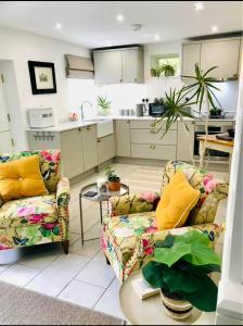 a living room with two couches and a kitchen at Flower Cottage by Ludlow Castle with Onsite Parking in Ludlow