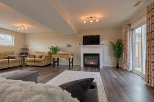 a living room with a fireplace and a tv at Cozy Cottage for Fall Getaways, Private backyard, decks in Meaford