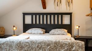 a bed with a black headboard and two pillows at Tanny Boho Housy na pešej zóne in Piešťany +47 photos