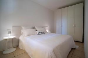 a white bedroom with a white bed and a white cabinet at Casa Ca D'oro in Cavallino-Treporti