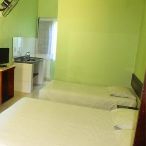 a hotel room with two beds and a sink at Enseada Marwille Pousada in Guarujá +8 photos