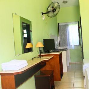 a bathroom with a desk with a mirror and a computer at Enseada Marwille Pousada in Guarujá
